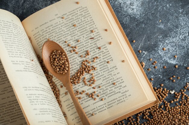 Raw buckwheat scattered on open book