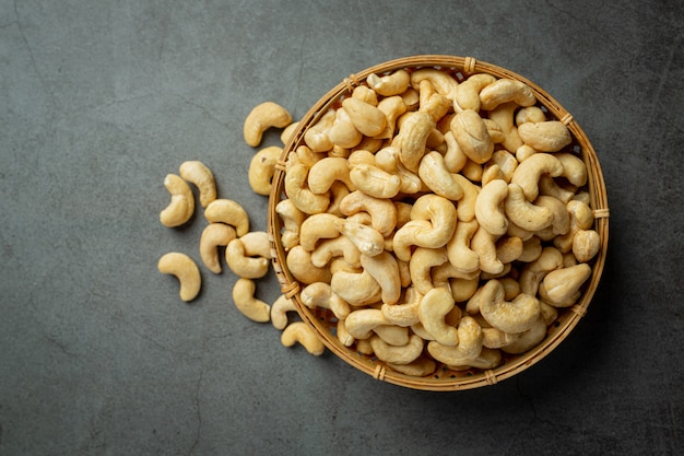 Raw cashews nuts in bowl on dark background