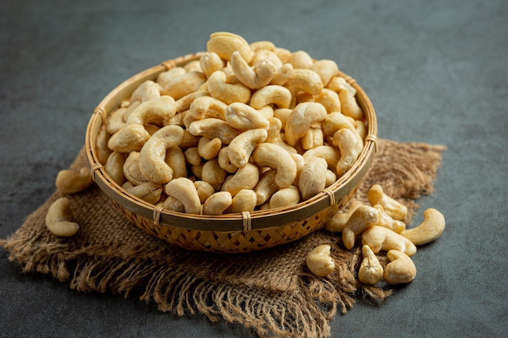 Raw cashews nuts in bowl on dark background