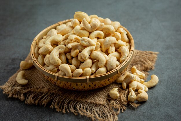 Raw cashews nuts in bowl on dark background