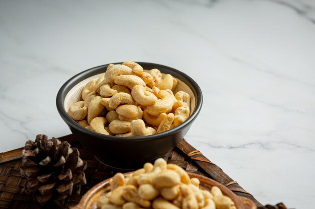 Raw cashews nuts in bowl on marble background