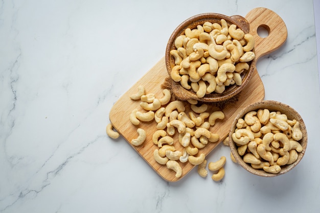 Raw cashews nuts in bowl on marble background