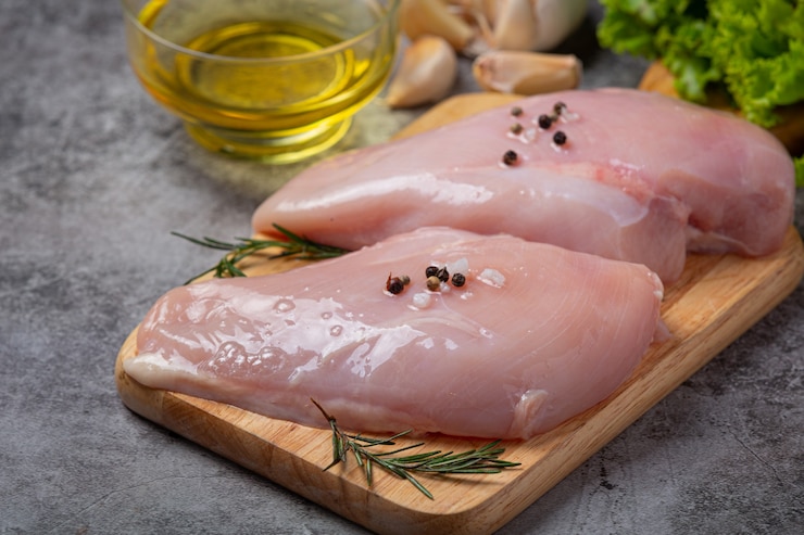 Бесплатный Фотография сырая куриная грудка на темной поверхности.