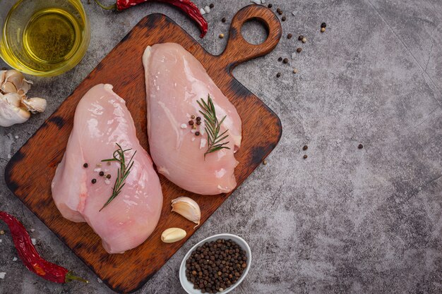 Raw chicken breast on the dark surface.