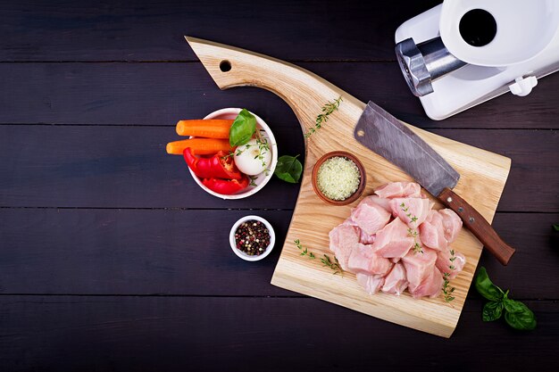 ハーブとスパイスを木製のまな板に生の鶏の胸肉の切り身。上面図