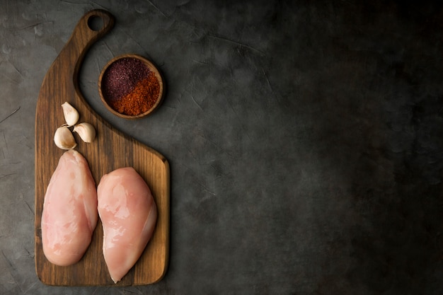 Raw chicken breast with garlic and spices