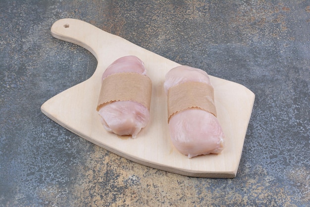 Raw chicken breasts on wooden board. High quality photo