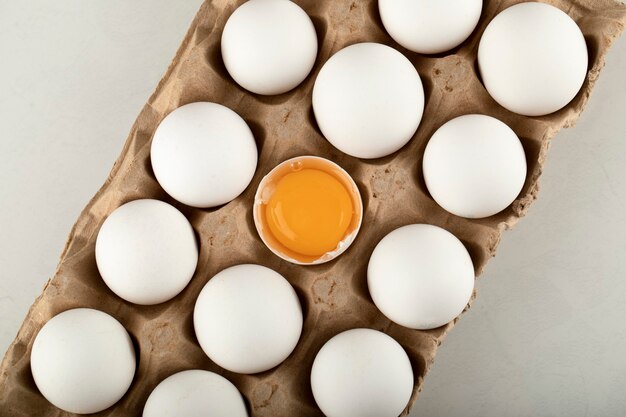 Raw chicken eggs in a carton container. 