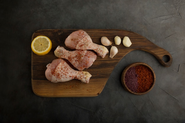 Free photo raw chicken legs served with lemon and spices