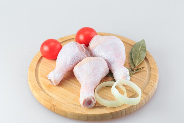 Raw chicken legs on white