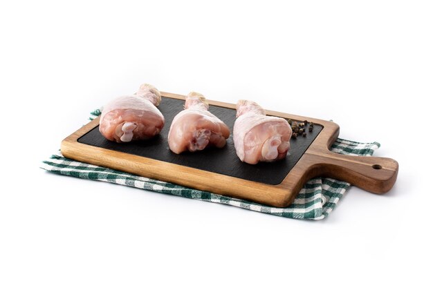白い背景で隔離まな板の生の鶏肉の足