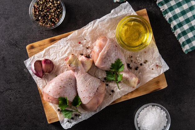 Foto gratuita cosce di carne di pollo cruda con spezie ed erbe aromatiche