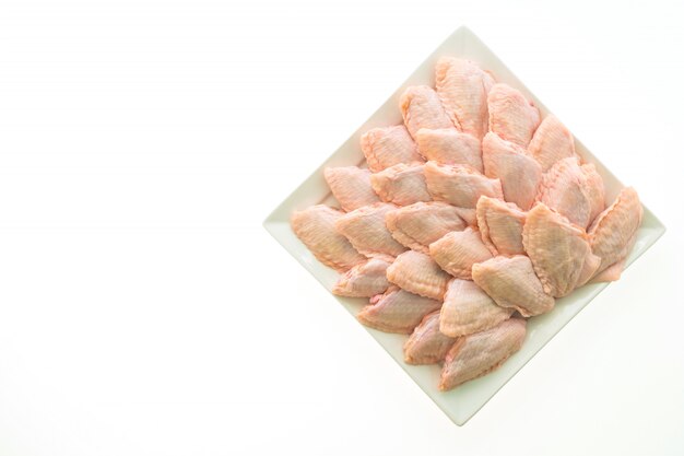 생 닭고기와 흰 접시에 날개