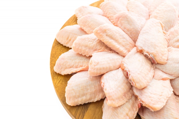 Raw chicken meat and wing on wooden cutting board or plate