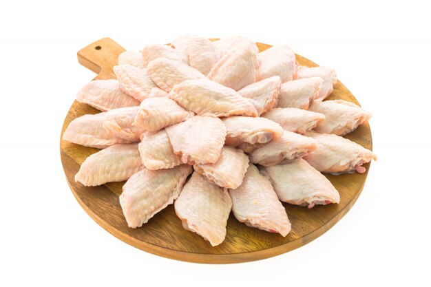 Сырое куриное мясо и крыло на деревянной разделочной доске или тарелке