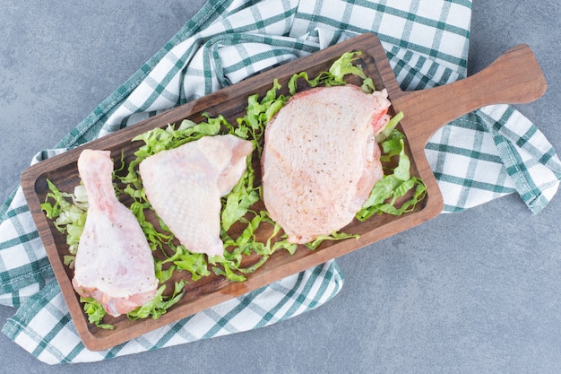 Free photo raw chicken parts on wooden board.