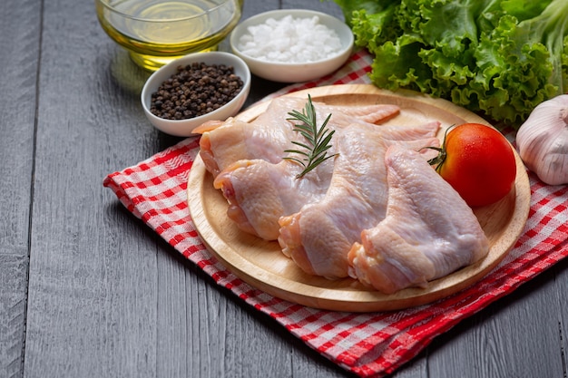 Free photo raw chicken wings on the dark wooden surface.