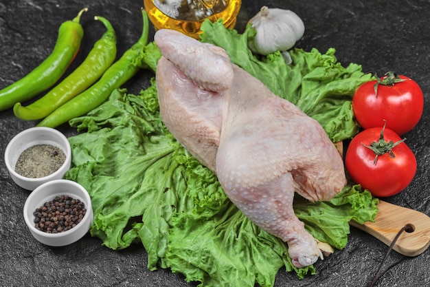 신선한 야채와 향신료의 무리와 함께 나무 보드에 원시 닭.