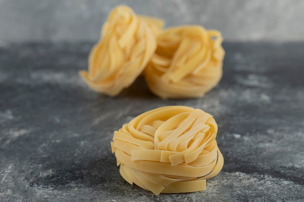 Raw dry nest noodles on a marble table . 