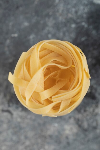 Raw dry nest noodles on a marble table . 