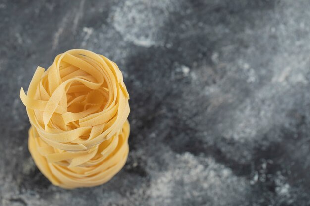 Raw dry nest noodles on a marble table . 