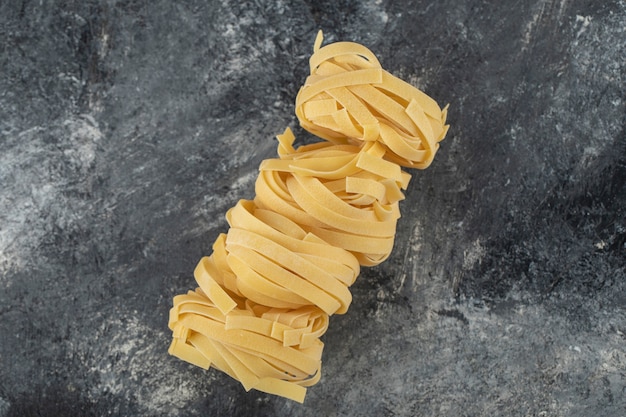 Free photo raw dry nest noodles on a marble table .