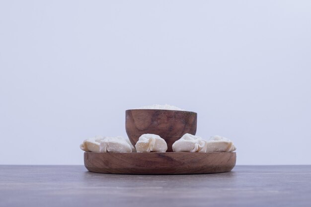 Raw dumplings on wooden board on marble surface