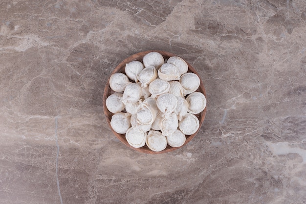 Raw dumplings on wooden board .