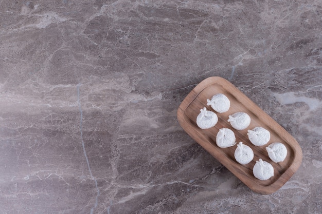 Raw dumplings on wooden board.