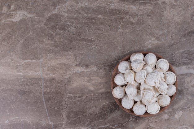 Raw dumplings on wooden board.