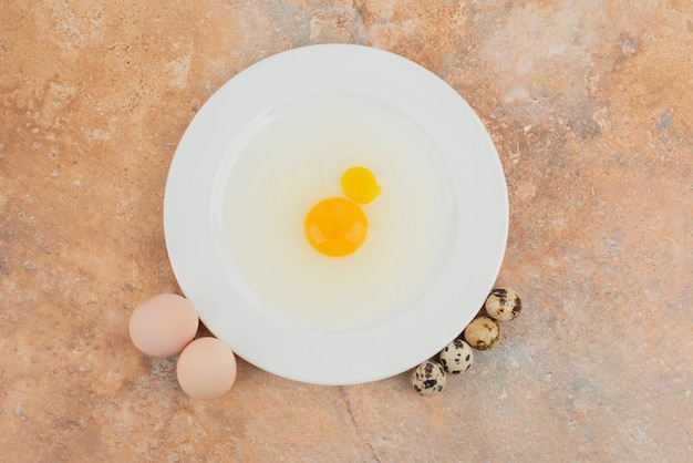 흰 접시와 여러 메추라기 달걀에 날 달걀.