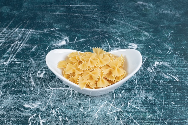 하얀 접시에 원시 farfalle 파스타입니다. 고품질 사진
