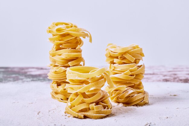 Raw fettuccine on grey surface. 