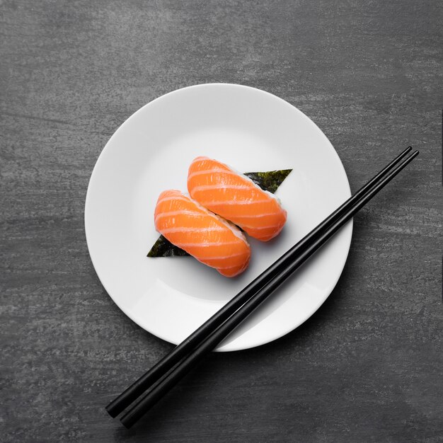 Сырая рыба на тарелке с видом сверху палочками
