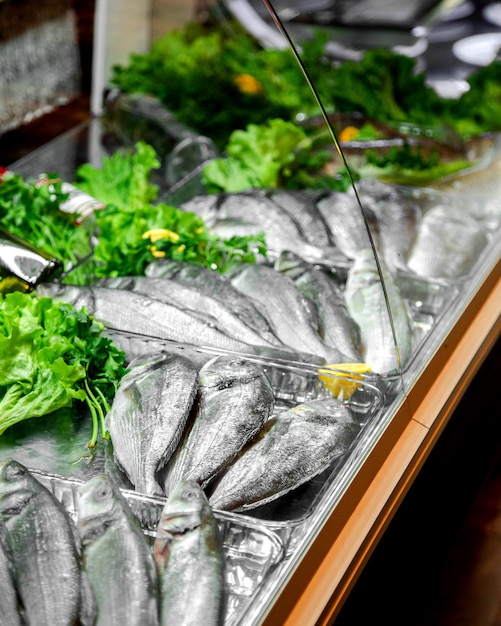 Сырая рыба в холодильнике на витрине ресторана