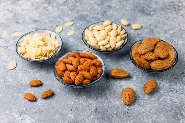 Raw fresh almonds with shell, without shelll, almond slices, top view