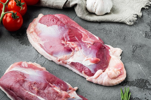 Raw fresh meat, duck breast fillet set, with herbs and ingredients, on gray stone background, top view flat lay
