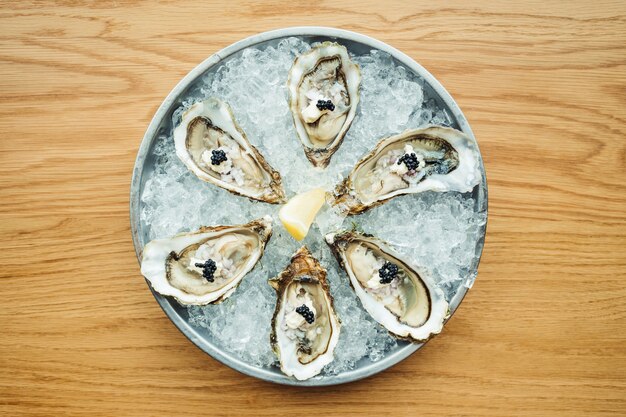 Raw and fresh Oyster with caviar on top and lemon