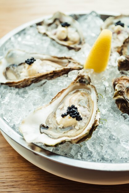 Raw and fresh Oyster with caviar on top and lemon