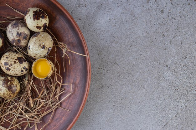 Raw fresh quail eggs placed on a stone surface. 