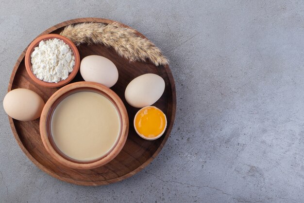 Raw fresh white chicken eggs placed on a stone surface. 