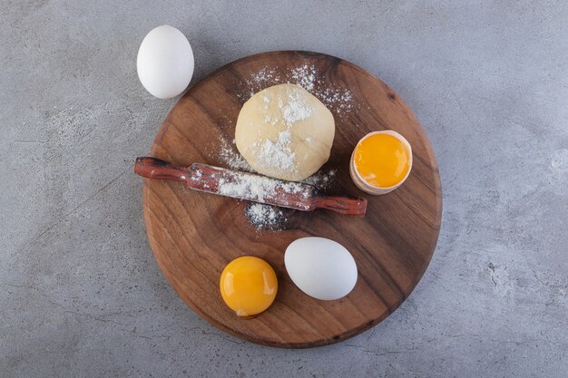 Raw fresh white chicken eggs placed on a stone surface. 