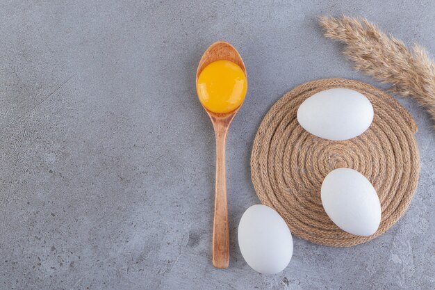원시 신선한 흰 닭고기 달걀은 돌 표면에 배치됩니다.