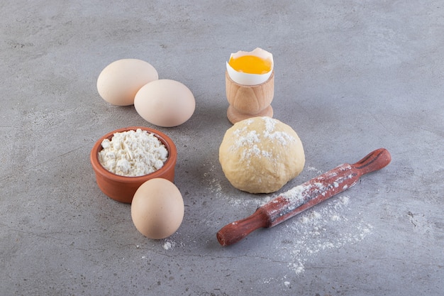 Raw fresh white chicken eggs placed on a stone surface. 