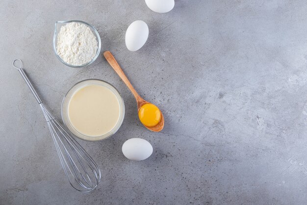 Raw fresh white chicken eggs with milk and flour . 