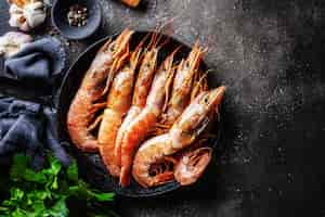 Free photo raw giant shrimps on dark table