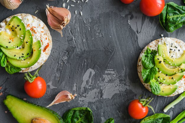 Raw ingredients with avocado; cream cheese and rice cake over textured background