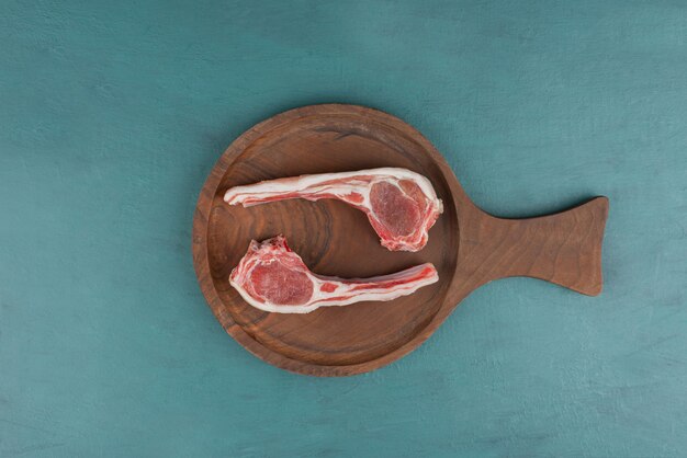 Raw lamb chops on wooden board