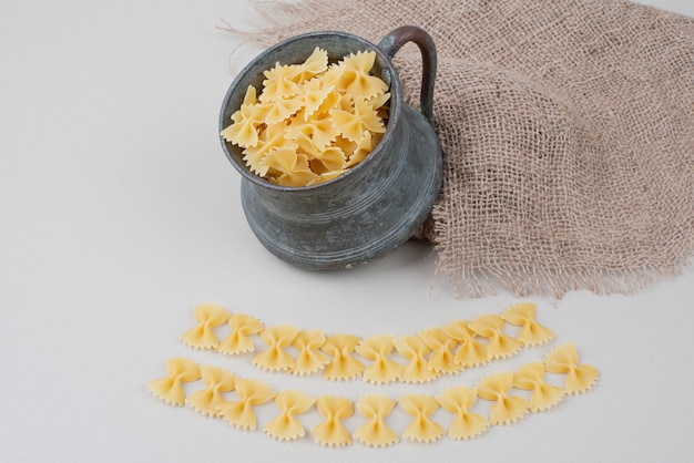 Raw macaroni in ancient kettle on burlap