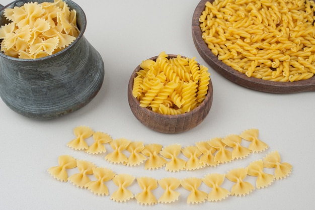 Raw macaroni on wooden plate.